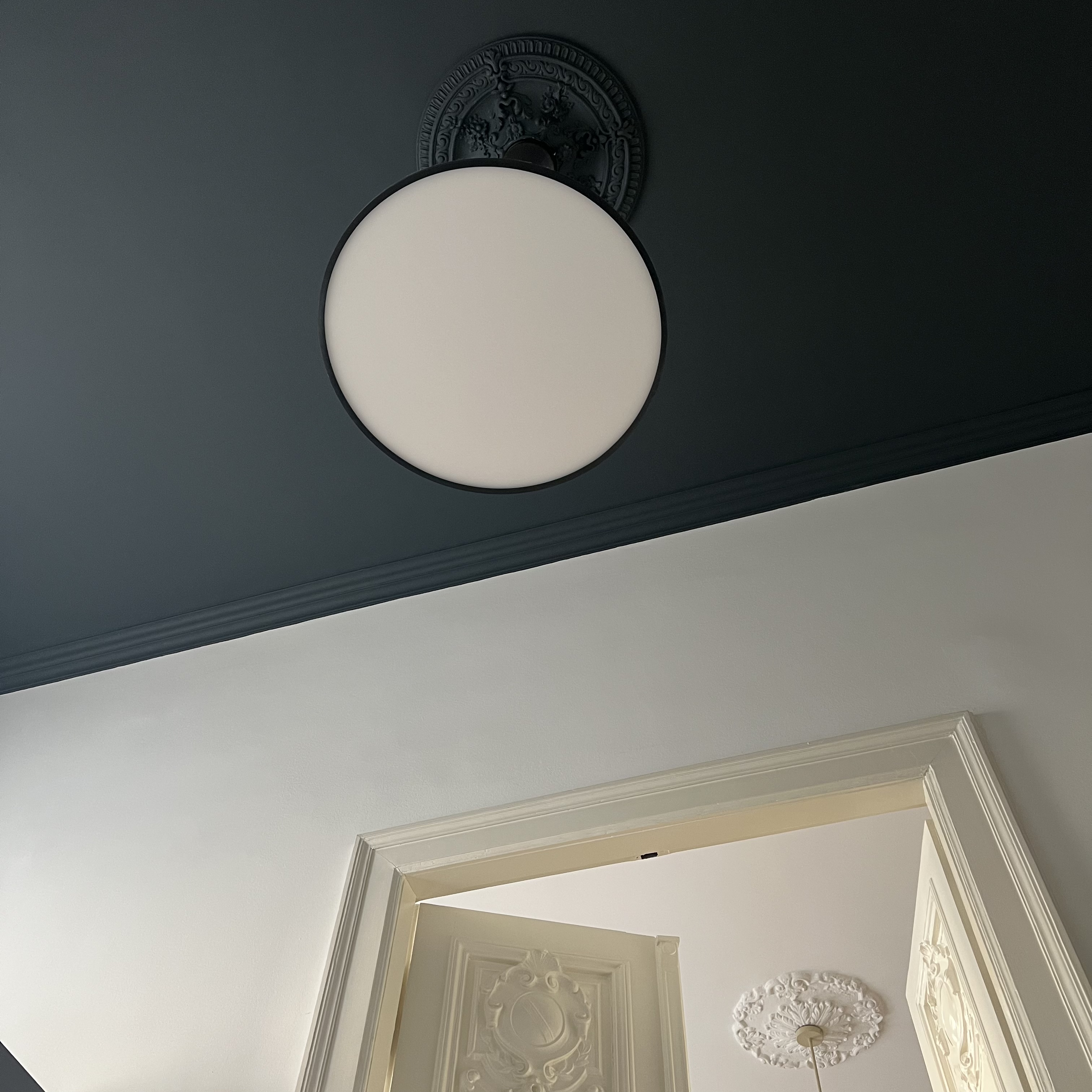 Deep teal ceiling with modern light fixture and classic moldings