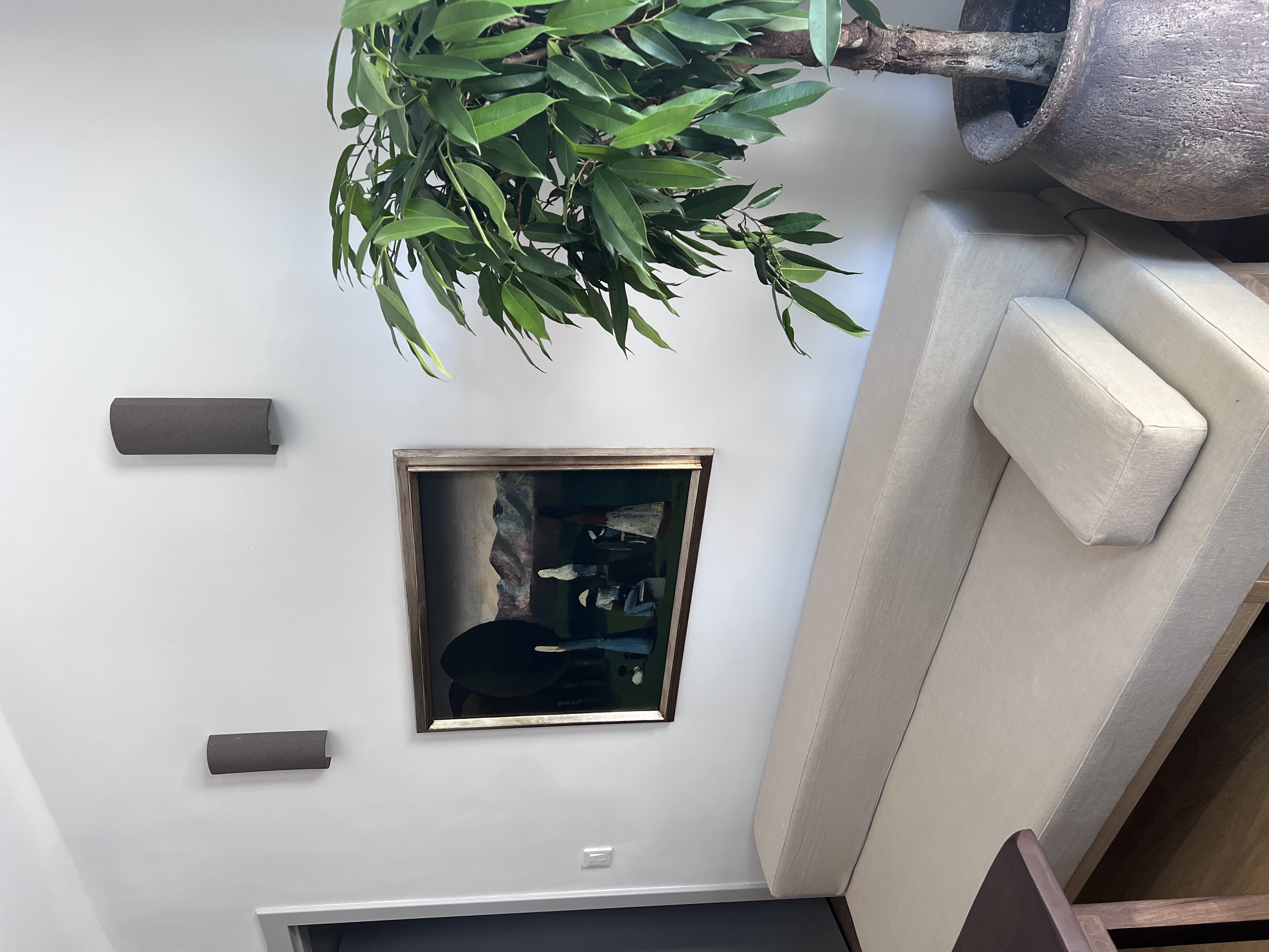 Living room corner with artwork, plants and sculptural vase